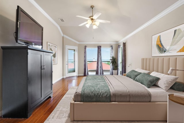 bedroom with crown molding, wood finished floors, visible vents, and vaulted ceiling