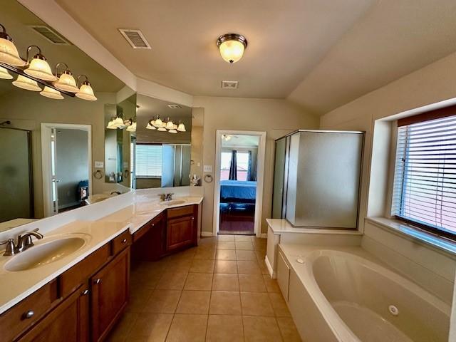 bathroom with tile patterned floors, visible vents, a sink, a shower stall, and double vanity