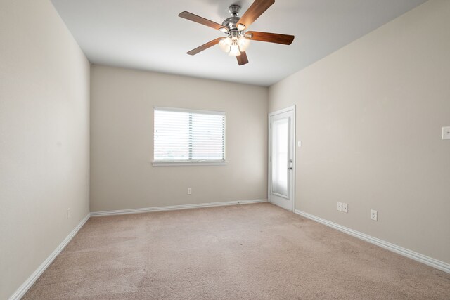 spare room with light carpet, baseboards, and a ceiling fan