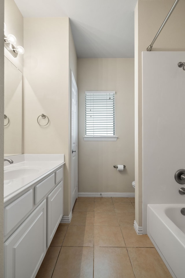 full bath featuring vanity, baseboards, tile patterned flooring, shower / tub combination, and toilet