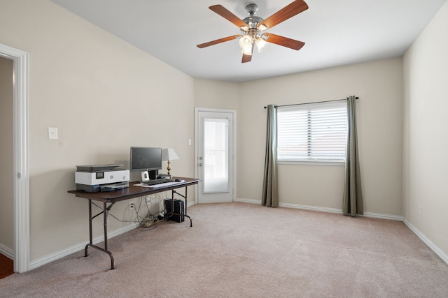 carpeted office space featuring baseboards and ceiling fan