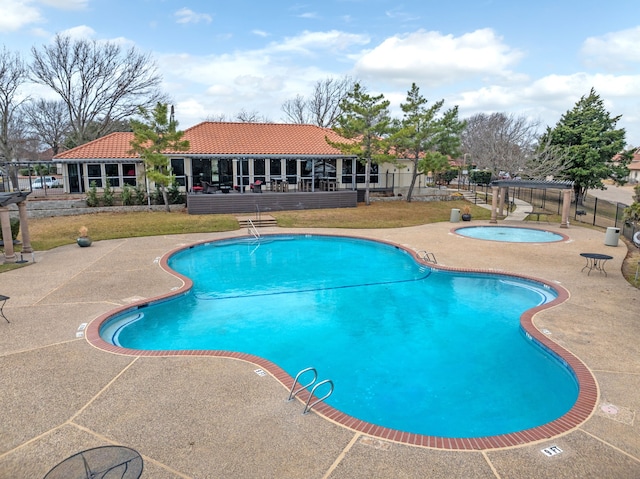 pool featuring a yard, a community hot tub, a patio, and fence