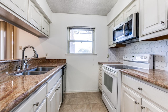 kitchen featuring dark stone countertops, sink, white cabinets, and white range with electric cooktop