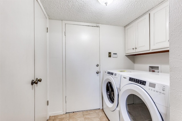 washroom with cabinets, washer and dryer, light tile patterned floors, and a textured ceiling