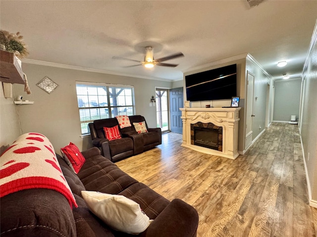 living room featuring ceiling fan, ornamental molding, and wood-type flooring