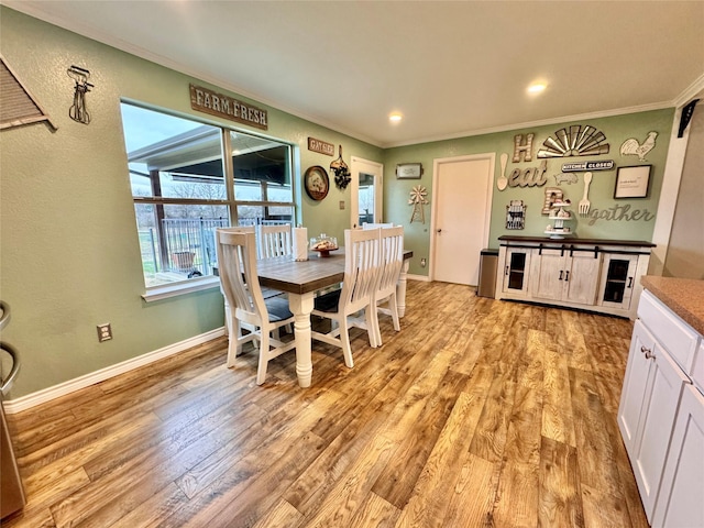 dining room featuring ornamental molding and light hardwood / wood-style flooring