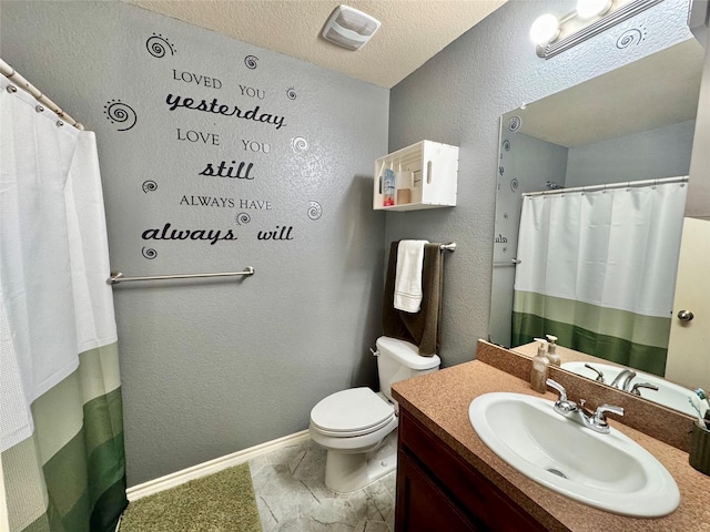 bathroom with vanity, a textured ceiling, and toilet