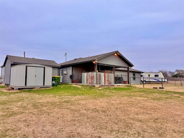 rear view of property featuring a lawn and a storage shed