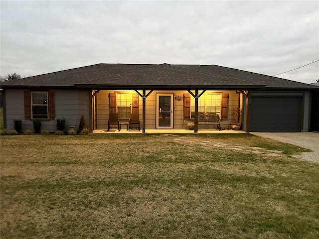 back of house with a garage and a lawn