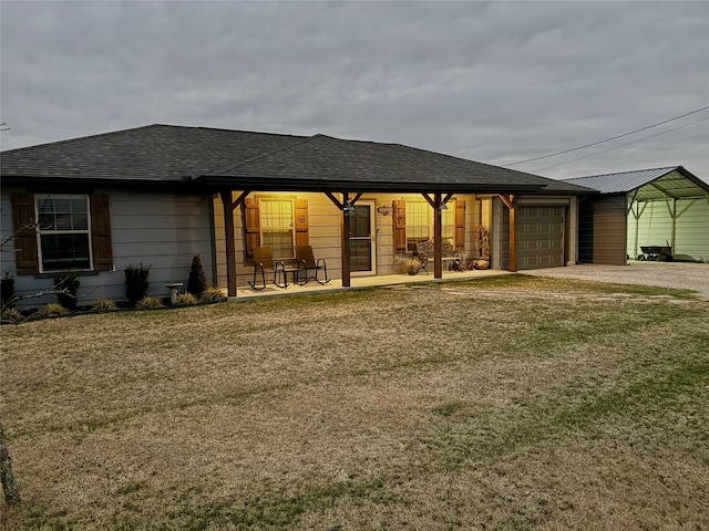 exterior space with a garage, a front lawn, and a carport