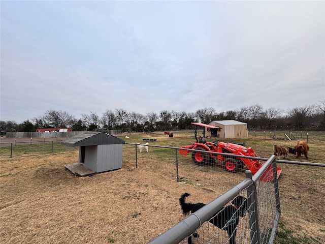 view of yard with a shed and a rural view