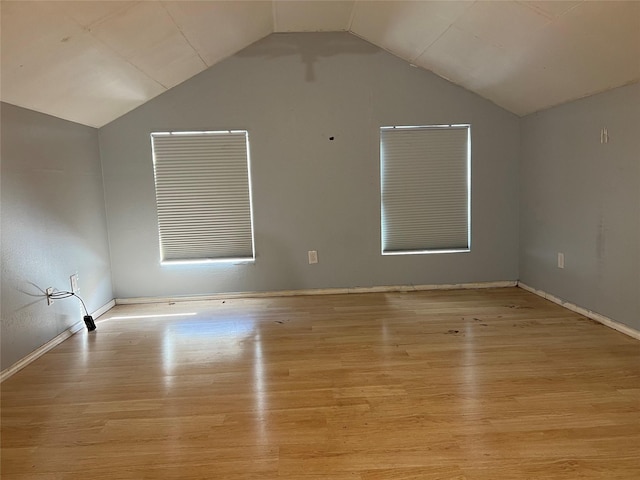 unfurnished room featuring vaulted ceiling and light wood-type flooring