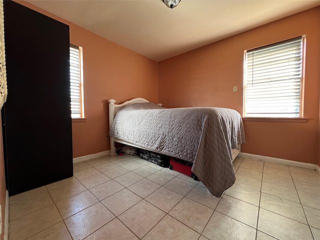 tiled bedroom featuring multiple windows