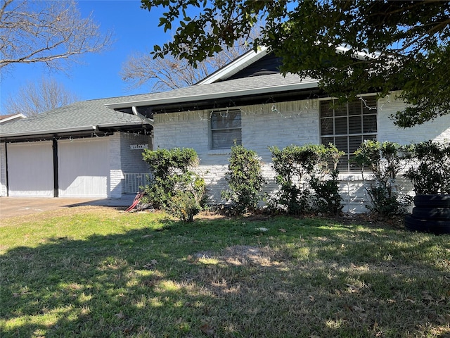 view of side of home with a garage and a lawn