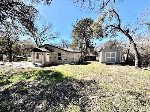 view of yard with a patio and a storage unit