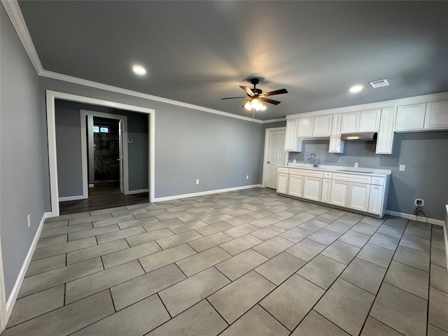 kitchen featuring sink, ceiling fan, ornamental molding, white cabinets, and light tile patterned flooring