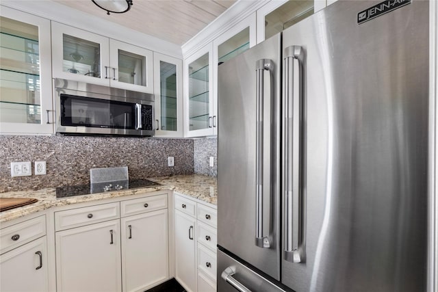 kitchen featuring light stone counters, stainless steel appliances, and white cabinets