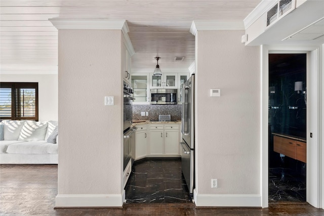 kitchen with appliances with stainless steel finishes, white cabinetry, backsplash, hanging light fixtures, and ornamental molding