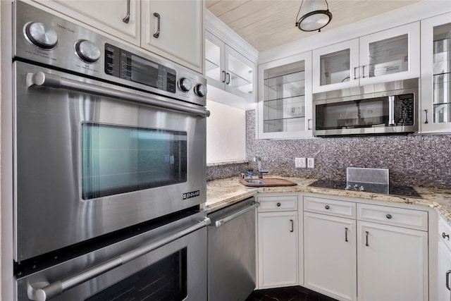 kitchen featuring decorative backsplash, white cabinets, and appliances with stainless steel finishes