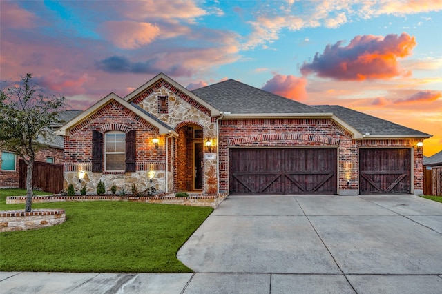 view of front of property with a garage and a yard