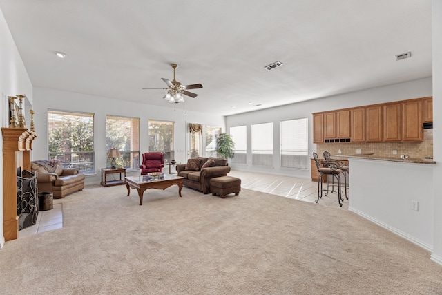 carpeted living room with ceiling fan and a healthy amount of sunlight