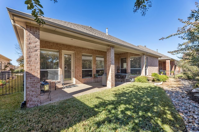 back of property with a lawn and a patio