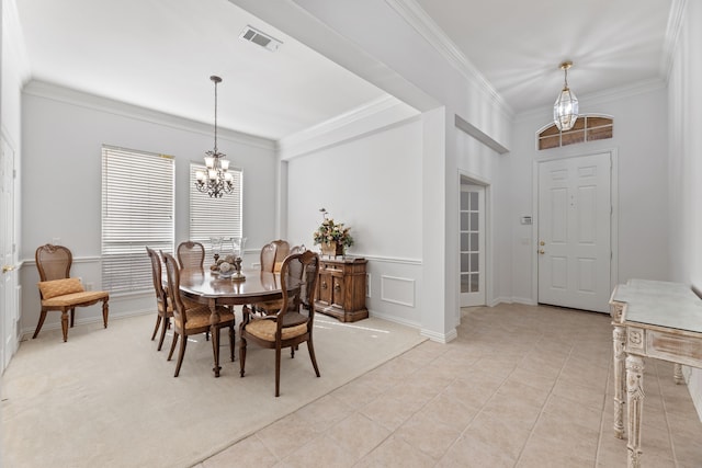 tiled dining space with an inviting chandelier and ornamental molding