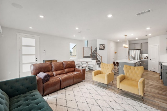 living room featuring sink and light hardwood / wood-style floors