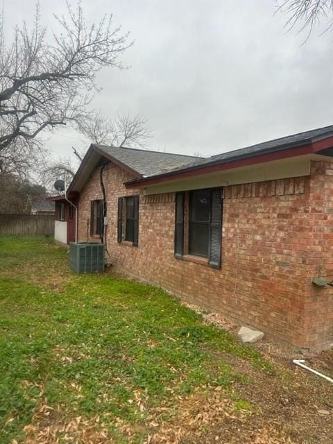 view of side of property featuring a yard and central air condition unit