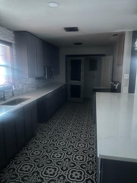 kitchen with light tile patterned flooring, sink, and decorative backsplash