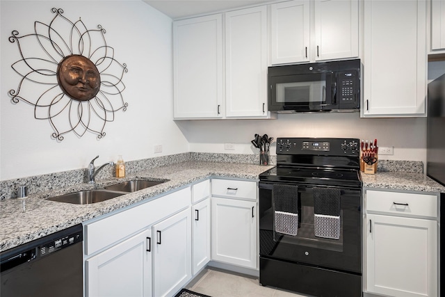 kitchen featuring sink, white cabinets, light stone counters, and black appliances