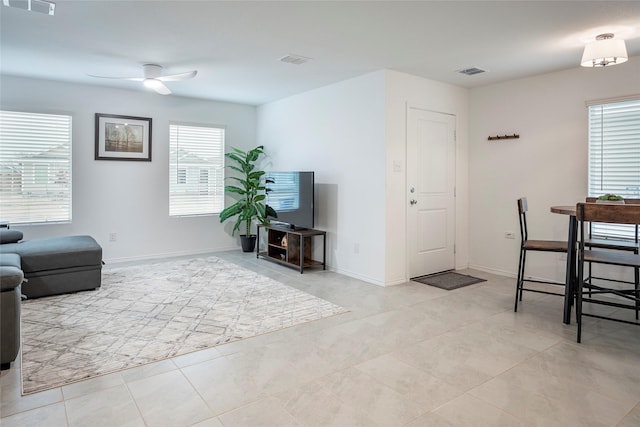 living room featuring light tile patterned floors and ceiling fan