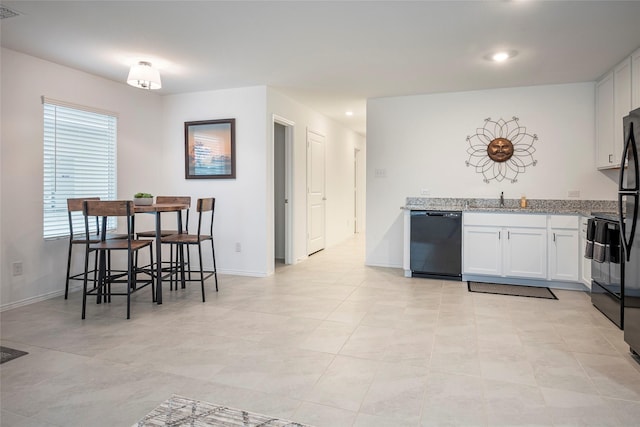 kitchen with electric range oven, black dishwasher, sink, white cabinets, and light stone countertops