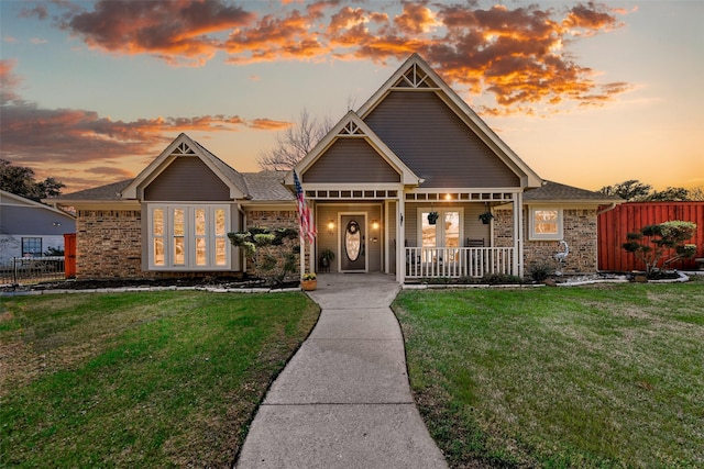 view of front of property featuring a porch and a lawn