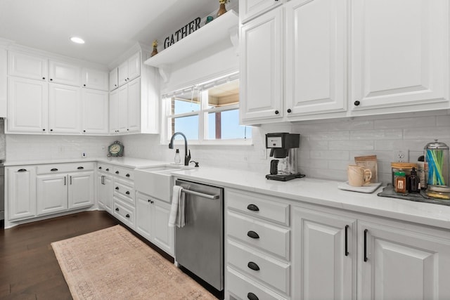 kitchen with sink, dark wood-type flooring, dishwasher, light stone counters, and white cabinets