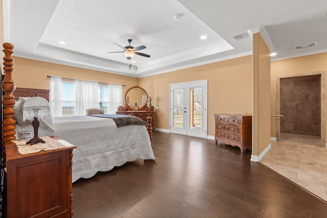 bedroom with a raised ceiling, wood-type flooring, access to outside, and french doors