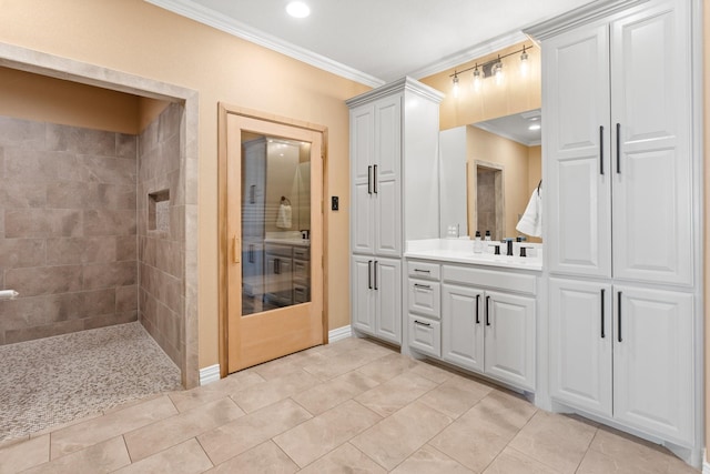 bathroom with crown molding, tile patterned floors, vanity, and a tile shower