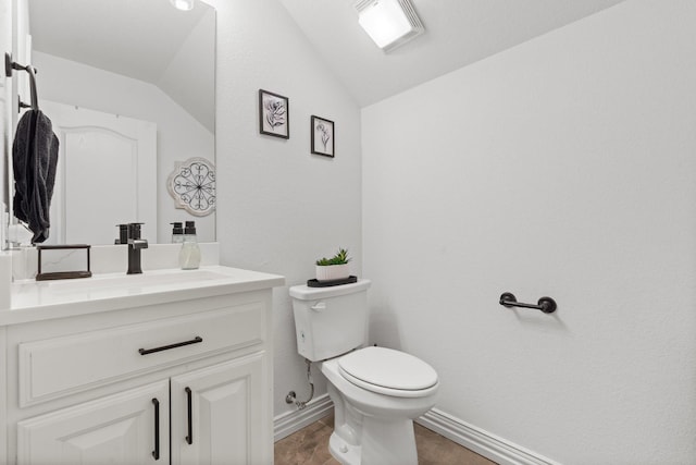 bathroom with vaulted ceiling, vanity, and toilet