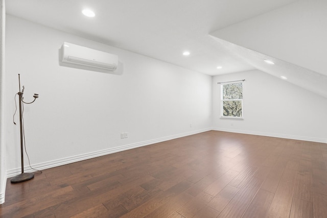 additional living space featuring wood-type flooring, vaulted ceiling, and a wall unit AC