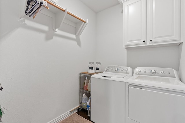 washroom with cabinets and washing machine and clothes dryer