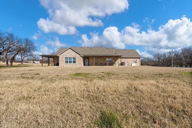 rear view of property featuring a yard