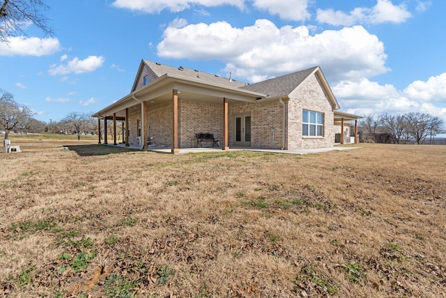 back of property featuring a yard and a patio