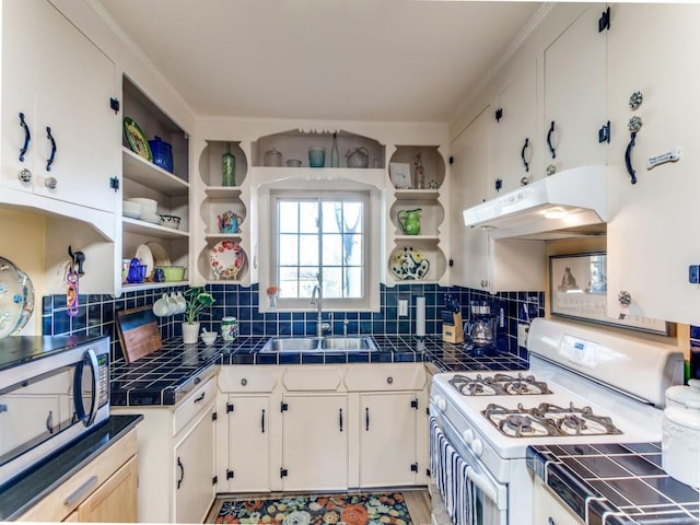 kitchen with white cabinetry, sink, tile counters, and white gas range oven