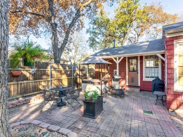 view of patio / terrace with grilling area and a hot tub