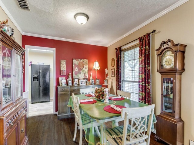 dining space with crown molding, dark hardwood / wood-style floors, and a textured ceiling