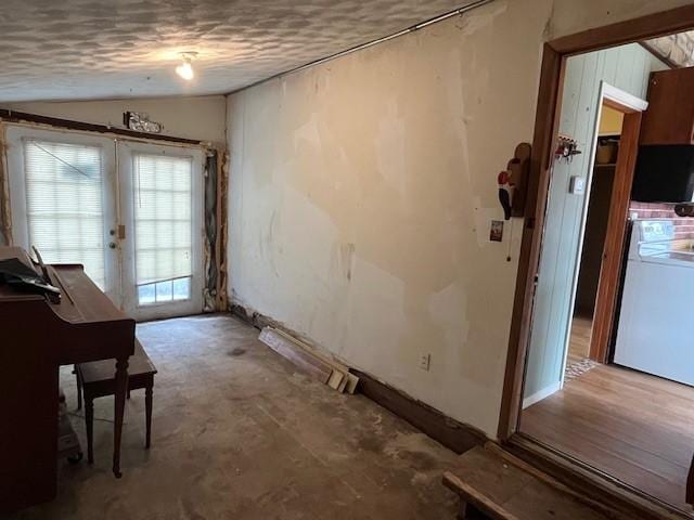 misc room featuring french doors, vaulted ceiling, and concrete floors