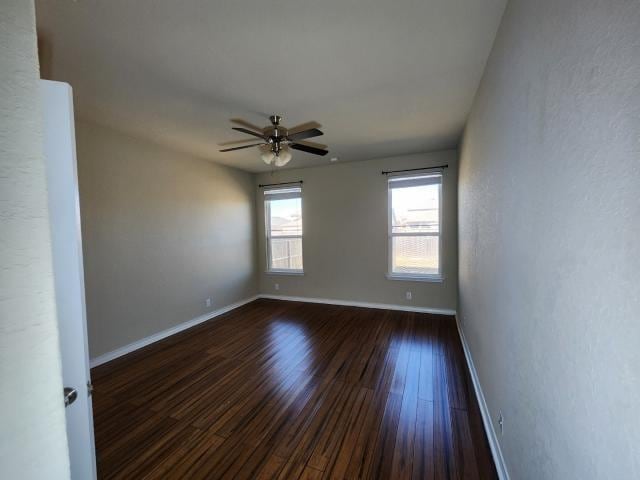 empty room featuring ceiling fan and dark hardwood / wood-style floors