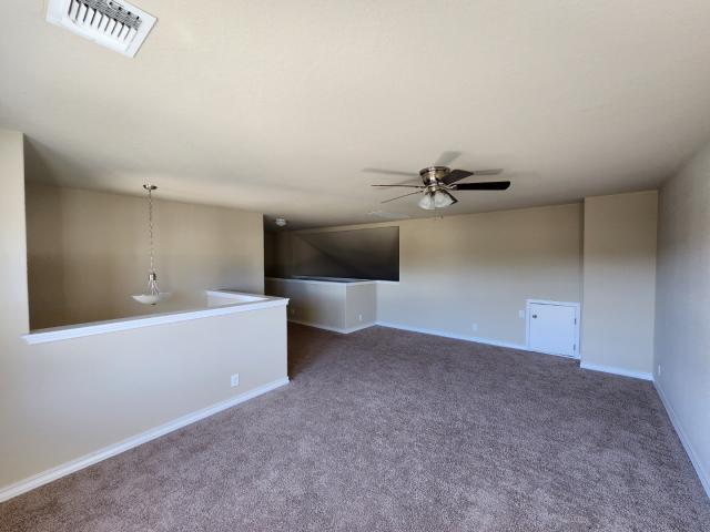 carpeted spare room with ceiling fan