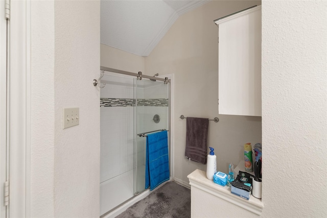 bathroom with a shower with door, ornamental molding, and lofted ceiling