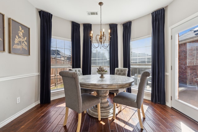 dining space with dark hardwood / wood-style flooring and a chandelier